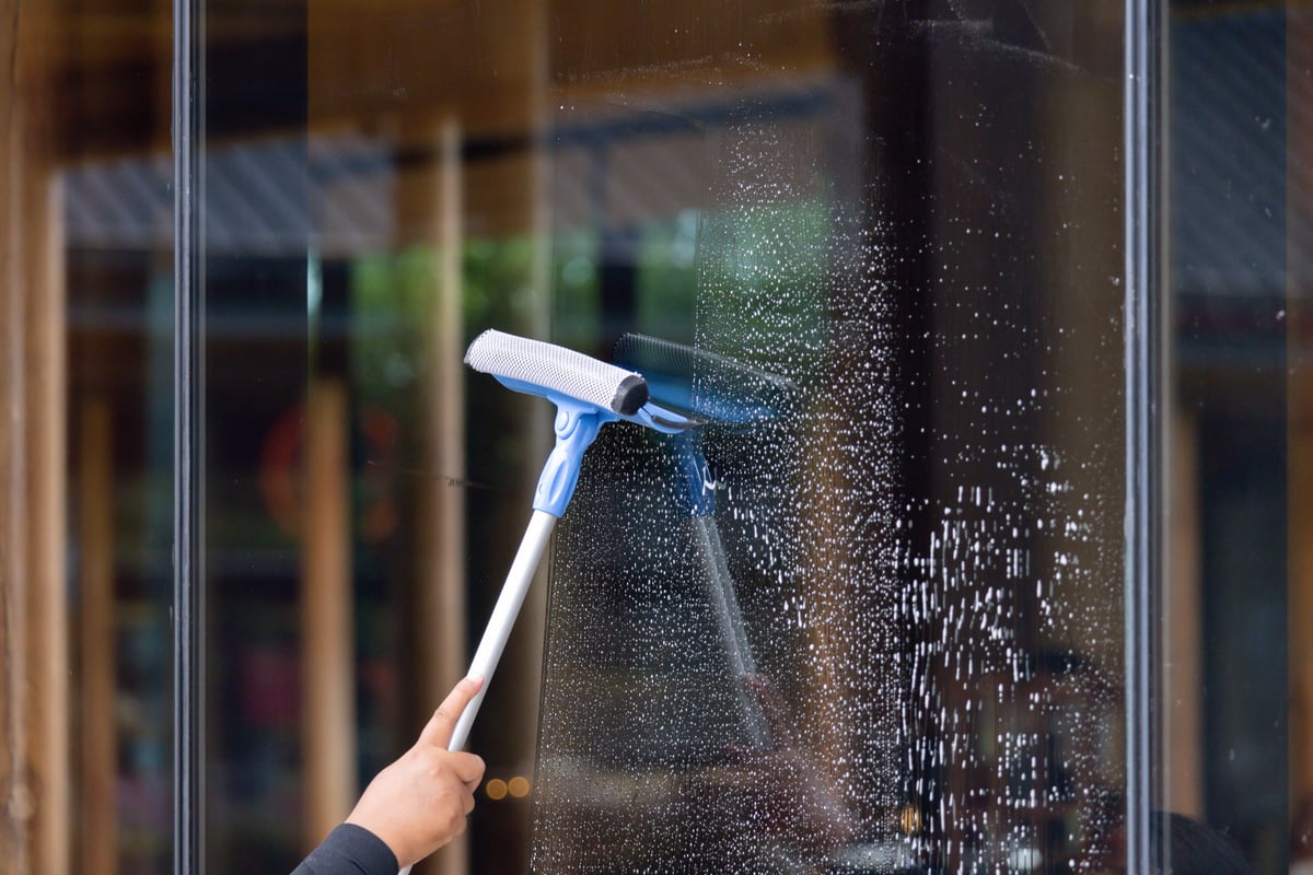 Professional window cleaning service with squeegee